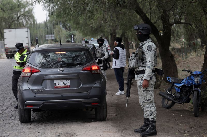 Members of the National Guard check drivers' documents at a checkpoint outside the Teotihuacan pyramids area, as the site reopens after being closed following an incident in which a gunman killed a Canadian woman and wounded several others before killing himself, according to authorities, in San Martin de las Piramides, on the outskirts of Mexico City, Mexico, April 22, 2026. Climbing the Moon pyramid remains suspended following the incident at the Teotihuacan pyramids, one of the country's most visited tourist sites. REUTERS/Henry Romero