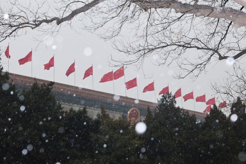 FILE PHOTO: Chinese national flags flutter on top of the Great Hall of the People amid snowfall ahead of the opening session of the Chinese People's Political Consultative Conference (CPPCC) in Beijing, China, March 4, 2026. REUTERS/Go Nakamura/ File Photo