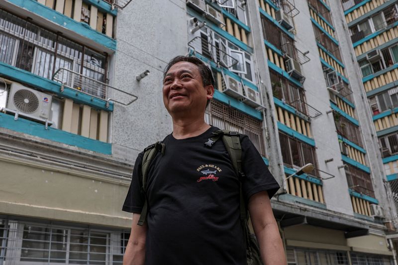Jason Kong, 65 years-old, walks towards a building at Wang Fuk Court to retrieve personal belongings during his first return visit after a deadly fire last year, in Hong Kong, China, April 23, 2026. REUTERS/Tyrone Siu
