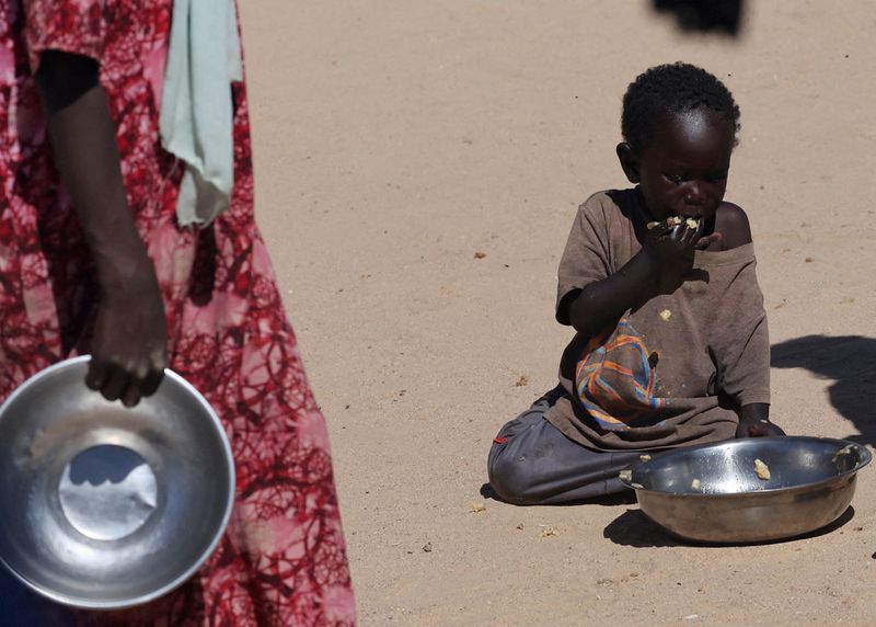 FILE PHOTO: A Sudanese orphaned child refugee from al-Fashir eats a free meal provided by the ?Group Kitchen Project? inside the Tine transit camp in eastern Chad, amid the conflict between the paramilitary Rapid Support Forces (RSF) and the Sudanese army, November 22, 2025. REUTERS/Amr Abdallah Dalsh/File Photo