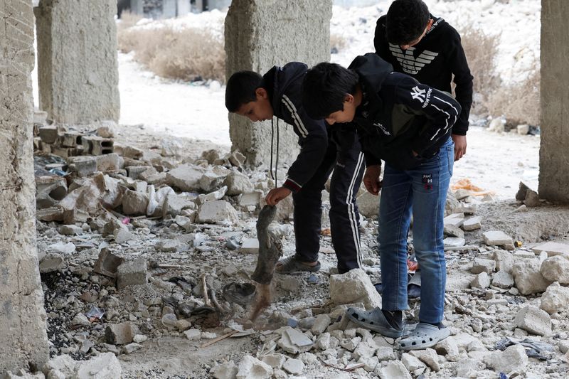 FILE PHOTO: Kids search and inspect bones amidst rubbles in Tadamon district, which is littered with bones after what residents and rights groups described as years of killings there under the rule of Syria's Bashar al-Assad, following al-Assad's ousting by fighters of the ruling Syrian body, in Damascus, Syria, December 12, 2024. REUTERS/Amr Abdallah Dalsh/File Photo