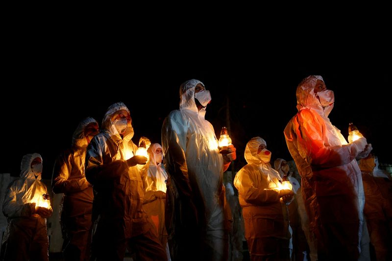 Members of the Chornobyl nuclear plant staff carry candles at a memorial dedicated to firefighters and workers who died after the 1986 Chornobyl nuclear disaster, during a night commemorative service to mark its 40th anniversary, amid Russia's attack on Ukraine, in Slavutych, Ukraine April 26, 2026. REUTERS/Valentyn Ogirenko