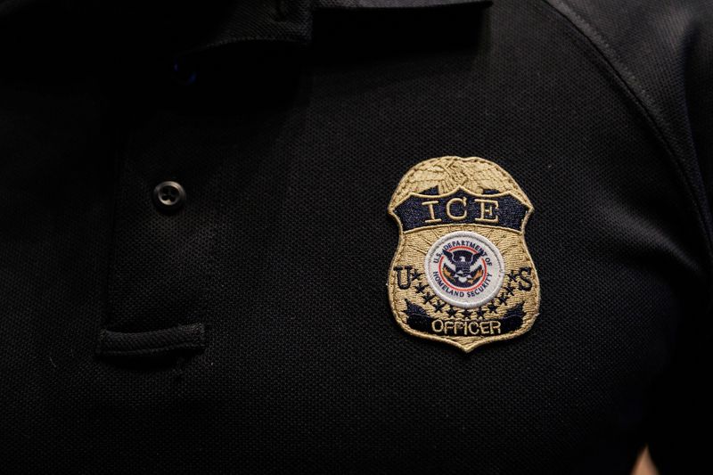 The badge of a U.S. Immigration and Customs Enforcement (ICE) is embroidered on a polo shirt of an ICE employee, in Arlington, Texas, U.S. August 26, 2025.  REUTERS/Shelby Tauber/File Photo