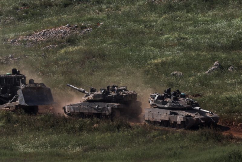FILE PHOTO: Tanks and an armoured vehicle drive in Lebanon, as seen from the Israeli side of the Israel-Lebanon border, in northern Israel, April 25, 2026. REUTERS/Florion Goga/File Photo