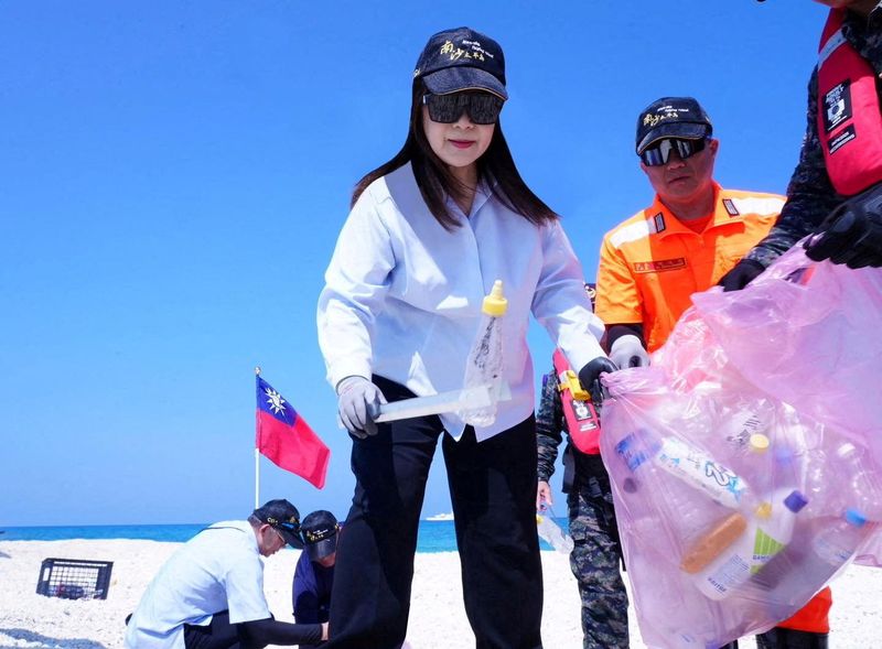 Taiwan's Ocean Affairs Council Minister Kuan Bi-ling and staff members work near a Taiwan's flag as they conduct a beach clean-up in a location given as the South China Sea in this handout image released on April 29, 2026.  Kuan Bi-ling via Facebook/Handout via REUTERS