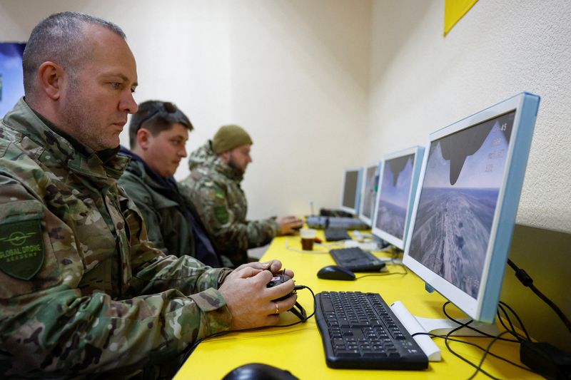 FILE PHOTO: Employees of a private security company use simulators to train to fly with an interceptor drone, amid Russia's attack on Ukraine, in an undisclosed location, Ukraine April 8, 2026. Ukrainian government recently allowed to involve private sector in the air defense system to protect critical infrastructure enterprises and facilities. REUTERS/Valentyn Ogirenko/File Photo