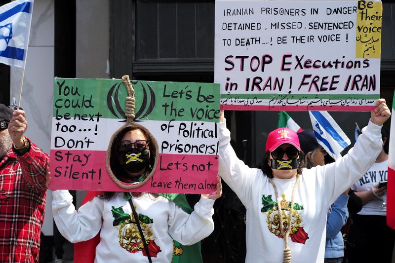 People display placards during a rally in support of U.S. President Trump's military actions towards Iran, while expressing dissatisfaction with the current ceasefire, in Toronto, Ontario, Canada, April 26, 2026. REUTERS/Wa Lone