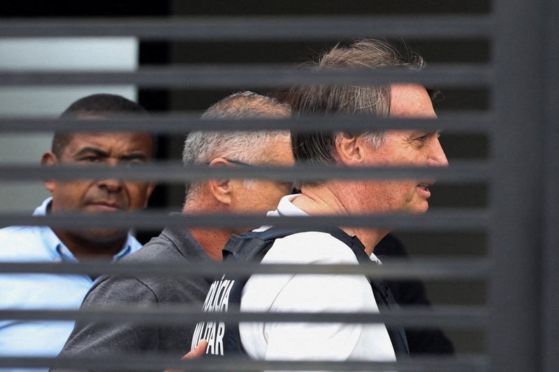 FILE PHOTO: Former Brazilian President Jair Bolsonaro arrives home to begin serving house arrest following authorization by Supreme Court Justice Alexandre de Moraes, after Bolsonaro was convicted by a Supreme Court majority of plotting a coup to remain in power after losing the 2022 election, in Brasilia, Brazil March 27, 2026. REUTERS/Adriano Machado /File Photo