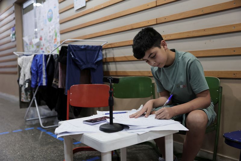 Mohamad Khalil, 11, displaced from southern Lebanon, attends an online class in Hariri High School II, used as a temporary shelter for displaced people, in Beirut, Lebanon, May 5, 2026. REUTERS/ Raghed Waked