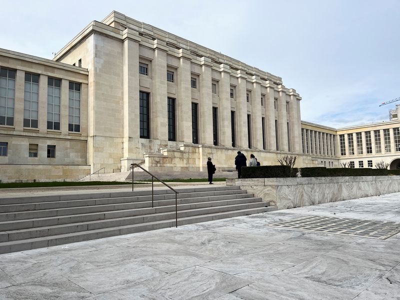 People stand in front of the Palais des Nations building, which serves as the European headquarters of the United Nations, in Geneva, Switzerland, March 16, 2026. Picture taken with a phone. REUTERS/Emma Farge