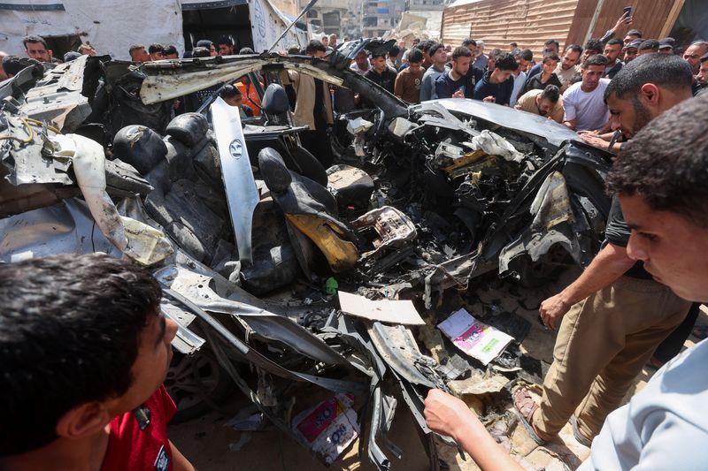 Palestinians inspect the site of an Israeli strike on a car in Khan Younis, in the southern Gaza Strip, May 10, 2026. REUTERS/Ramadan Abed