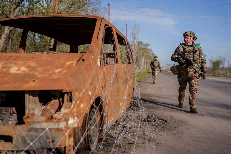 Servicemen of the consolidated Brigade 'Khyzhak' of the Ukrainian Patrol Police Department walk along a street under an anti-drone net in the town of Druzhkivka, amid Russia's attack on Ukraine, in Donetsk region, Ukraine April 28, 2026. REUTERS/Serhii Korovainyi