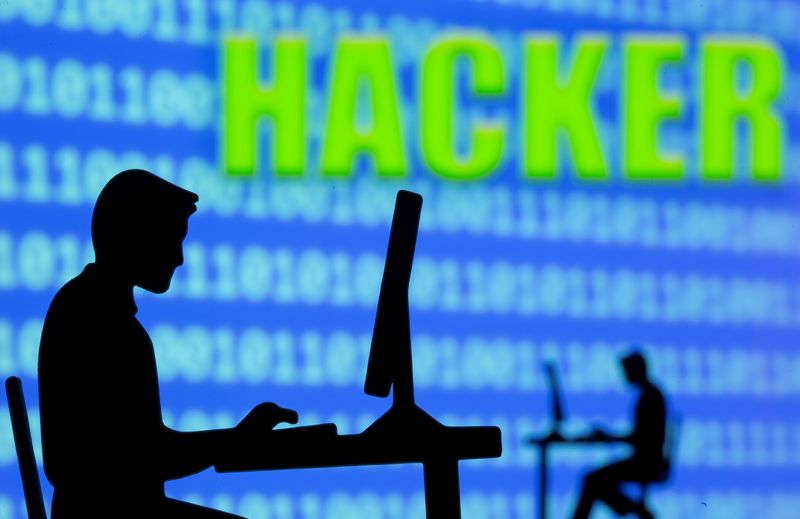 A 3D printed model of men working on computers are seen in front of displayed binary code and words "Hacker" in this illustration taken, July 5, 2021. REUTERS/Dado Ruvic/Illustration/File Photo