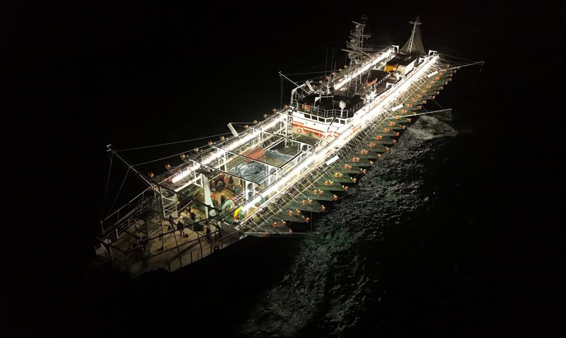A drone view shows crew members aboard a squid jigger vessel operating outside Argentina's exclusive economic zone, where foreign fishing vessels, mostly Chinese, operate just beyond the boundary, in the South Atlantic Ocean off the coast of Argentina, January 18, 2026. REUTERS/Agustin Marcarian