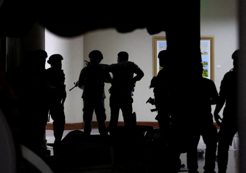 FILE PHOTO: Military personnel in camouflage fatigues enter the Senate building where Philippine Senator Ronald "Bato" dela Rosa, the chief enforcer of former president Rodrigo Duterte's drug war, at the Senate, is under protective custody amid an International Criminal Court warrant, as more than a dozen gunshots were heard at the Philippine Senate on Wednesday, and people were told to run for cover, according to a Reuters witness, in Pasay City, Metro Manila, Philippines, May 13, 2026. REUTERS/Eloisa Lopez       TPX IMAGES OF THE DAY/File Photo