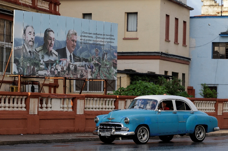 A vintage car passes by images of late Cuban President Fidel Castro, Cuba's former President Raul Castro and Cuba's President Miguel Diaz-Canel displayed on a billboard in Havana, Cuba, May 15, 2026. REUTERS/Norlys Perez