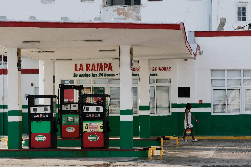 A woman walks past an empty gas station as the country plans to implement variable fuel prices to reflect the actual costs of importing gasoline and diesel amid a U.S. blockade that has strangled the island of fuel, in Havana, Cuba, May 15, 2026. REUTERS/Norlys Perez