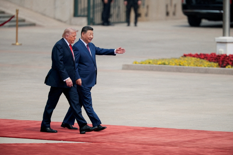 FILE PHOTO: U.S. President Donald Trump walks with Chinese President Xi Jinping upon arrival at the Great Hall of the People in Beijing, China, May 14, 2026. REUTERS/Evan Vucci/File Photo