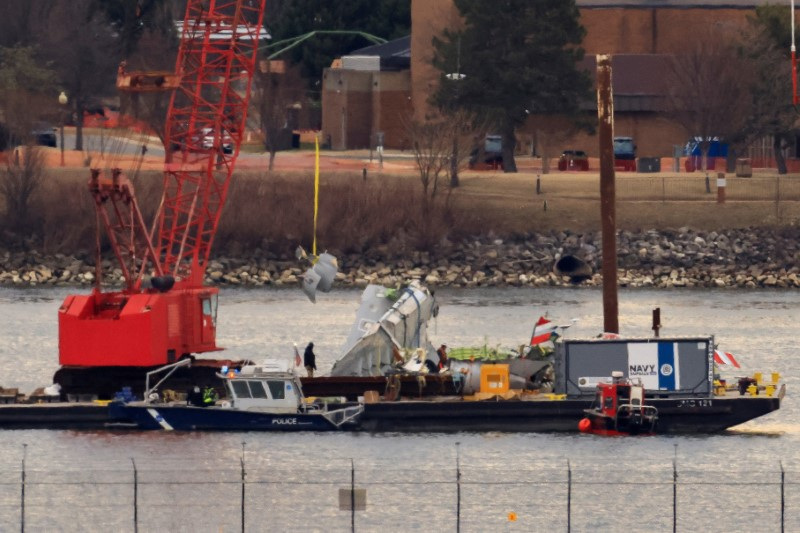 FILE PHOTO: A crane retrieves part of the wreckage from the Potomac River, in the aftermath of the collision of American Eagle flight 5342 and a Black Hawk helicopter that crashed into the river, by the Ronald Reagan Washington National Airport, in Arlington, Virginia, U.S., February 5, 2025.  REUTERS/Eduardo Munoz/File Photo