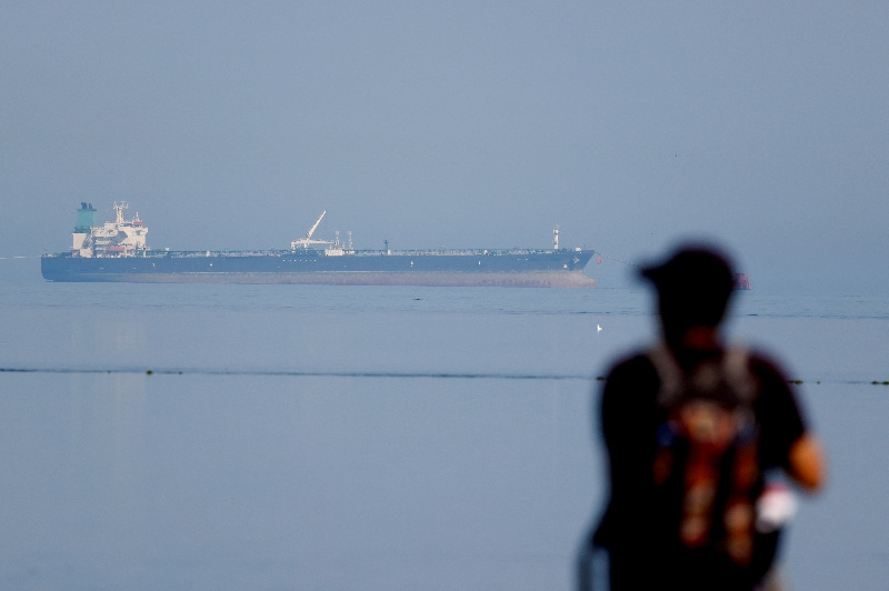 FILE PHOTO: A tourist watches the MT Desert Kite oil tanker carrying Russian oil at Narara Marine National Park in the Arabian Sea, Gujarat, India, March 11 , 2026. REUTERS/Amit Dave/File Photo