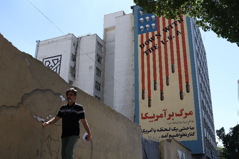 A man walks past an anti-U.S. mural on a building in Tehran, Iran, May 18, 2026. Majid Asgaripour/WANA (West Asia News Agency) via REUTERS