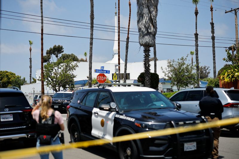 Emergency workers respond at the scene of a reported active shooter situation at the Islamic Center, with yellow tape to cordon the area in the foreground, in San Diego, California, U.S., May 18, 2026.  REUTERS/Mike Blake