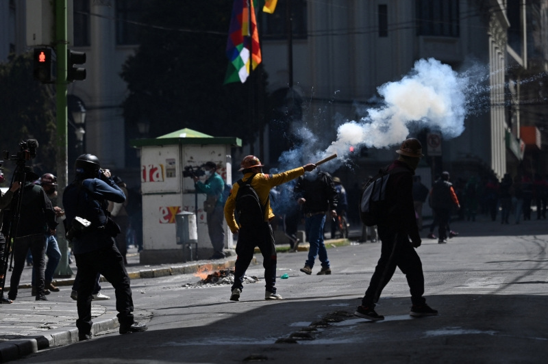 A demonstrator launches a firecracker during a march calling for the resignation of Bolivia's President Rodrigo Paz, as the country's economic and fuel crisis worsens due to a shortage of U.S. dollars and falling domestic energy production, in La Paz, Bolivia May 18, 2026. REUTERS/Claudia Morales