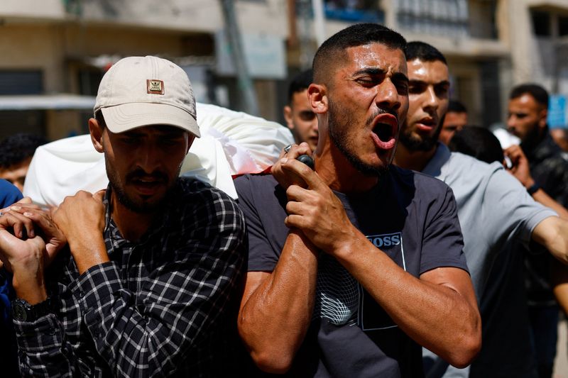 People carry bodies identified by mourners as Hamas' military wing commander Mohammad Odeh, who was killed in an Israeli strike on Tuesday, and his wife and children, during a funeral, in Gaza City, May 27, 2026. REUTERS/Mahmoud Issa