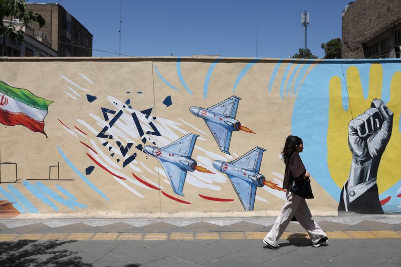 An Iranian woman walks next to an anti-Israeli mural on a street in Tehran, Iran, May 30, 2026. Majid Asgaripour/WANA (West Asia News Agency) via REUTERS
