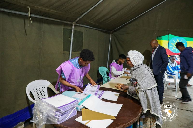 National Election Board of Ethiopia (NEBE) officials process a voter before casting her ballot at a polling station during the parliamentary and regional elections in Addis Ababa, Ethiopia, June 1, 2026. The Intergovernmental Authority on Development (IGAD)/Handout via REUTERS