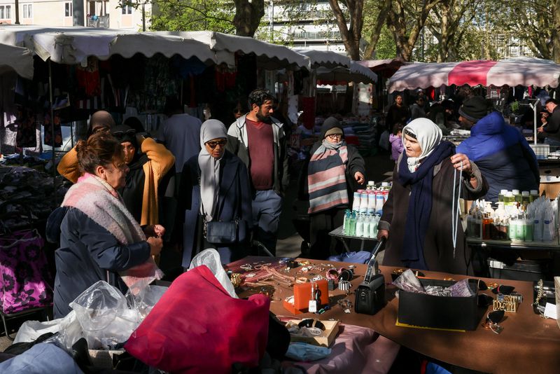 Shoppers browse items in the 800 metre-long Tuesday Market in Sarcelles, which has vendors selling food, clothing, homeware products and handicrafts to cater for Sarcelles' diverse immigrant community in the Paris suburb of Sarcelles, France, April 14, 2026. REUTERS/Tom Nicholson