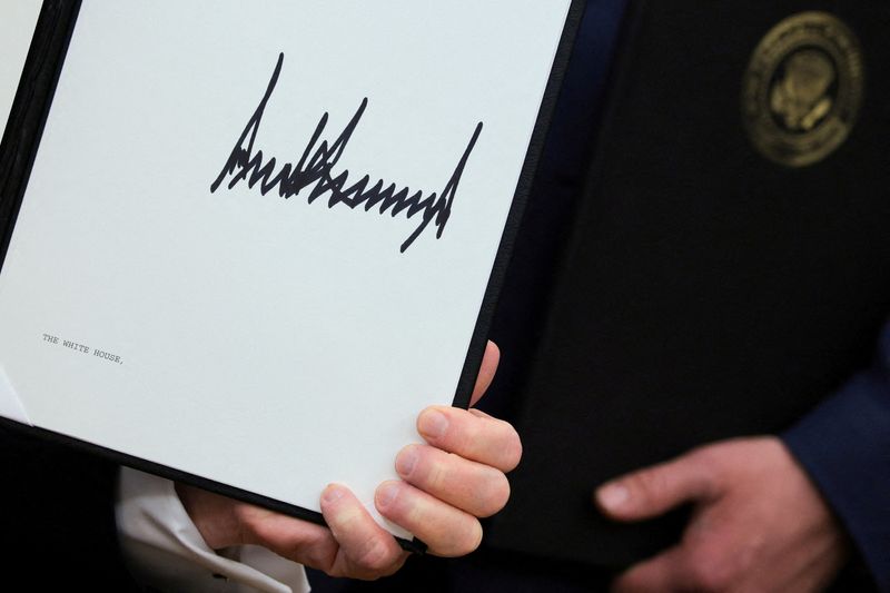 FILE PHOTO: U.S. President Donald Trump holds an executive orders he signed the Oval Office at the White House in Washington, D.C., U.S., April 30, 2026. REUTERS/Jonathan Ernst/File Photo