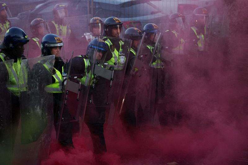 Police officers stand guard amid colored smoke during a demonstration following the conviction of Vikrum Digwa for the murder of student Henry Nowak, in Southampton, Britain, June 2, 2026. REUTERS/Isabel Infantes     TPX IMAGES OF THE DAY