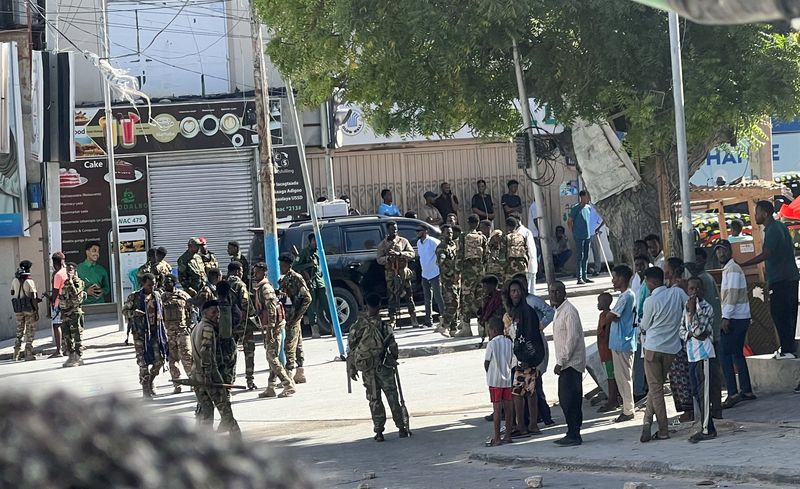 Members of Somali government forces stand among civilians at a street junction ahead of a planned protest against Somalia's President Hassan Sheikh Mohamud over his decision to remain in office after his term expired last month, in Mogadishu, Somalia, June 4, 2026. Picture taken with a mobile phone. REUTERS/Feisal Omar