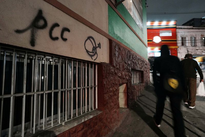 People walk past a sign reading "PCC", referring to Brazilian drug gang Primeiro Comando da Capital, after U.S. Secretary of State Marco Rubio announced a policy to designate "PCC" and Comando Vermelho "CV" as foreign "terrorist organizations", in Sao Paulo, Brazil, May 29, 2026. REUTERS/Alexandre Meneghini