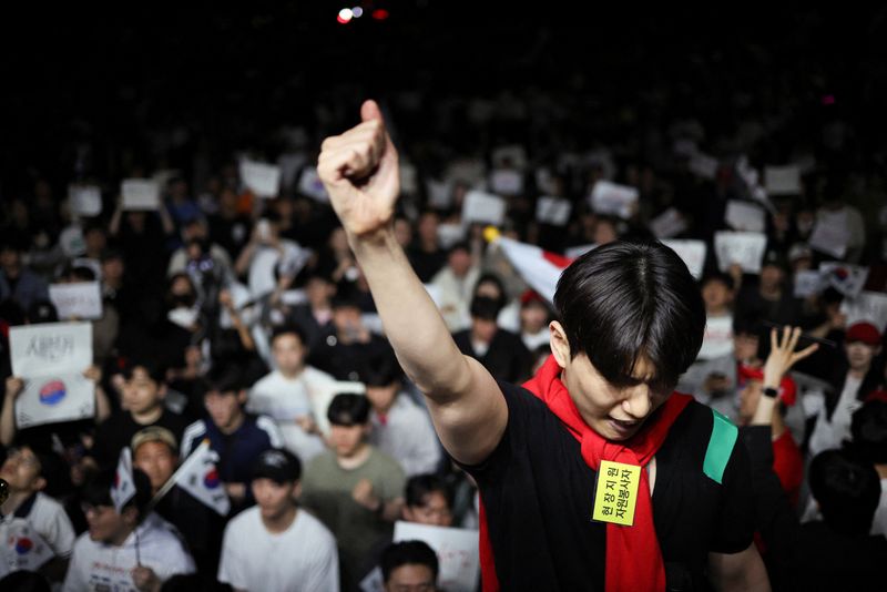 A demonstrator raises his fist as people surround a vote-counting centre to protest a controversy over a shortage of ballot papers that disrupted voting in the local election and to call for a rerun of the election, in Seoul, South Korea, June 6, 2026. REUTERS/Kim Hong-Ji