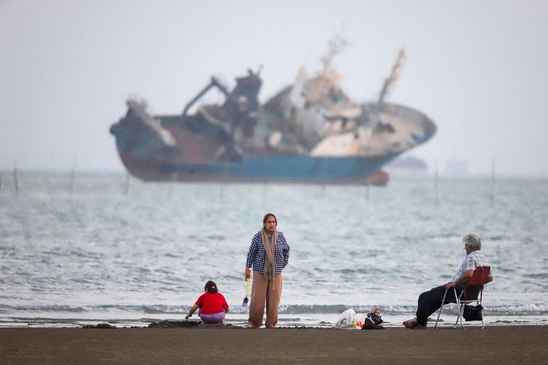 People gather on a beach, as a vessel in the Strait of Hormuz is visible, near the beach of Bandar Abbas, Iran, May 31, 2026.  Amirhosein Khorgooi/ISNA/WANA (West Asia News Agency) via REUTERS