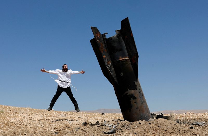 An Israeli ultra-Orthodox Jewish man reacts near a part of a missile protruding from the ground, following strikes from Iran, in the central Israeli-occupied West Bank, June 8, 2026. REUTERS/Ammar Awad