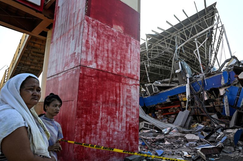 People look at a collapsed grocery store a day after the magnitude 7.8 earthquake, in Calumpang, General Santos, southern Philippines, June 9, 2026. REUTERS/Noel Celis