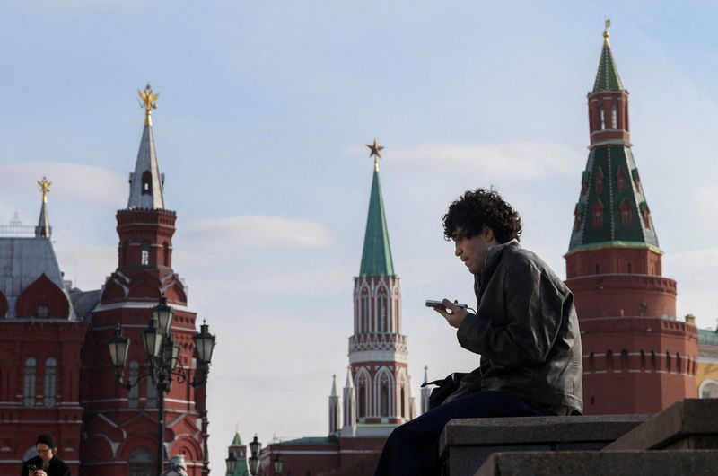 FILE PHOTO: A man checks his mobile phone in central Moscow, Russia, March 17, 2026. REUTERS/Ramil Sitdikov/File Photo