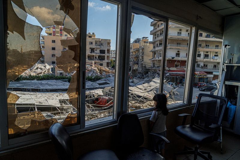 A displaced girl stands at the broken window of Jabal Amel hospital where she has taken shelter with her family, overlooking buildings damaged by Israeli strikes, following a deal between the U.S. and Iran, in Tyre, southern Lebanon, June 16, 2026. REUTERS/Zohra Bensemra