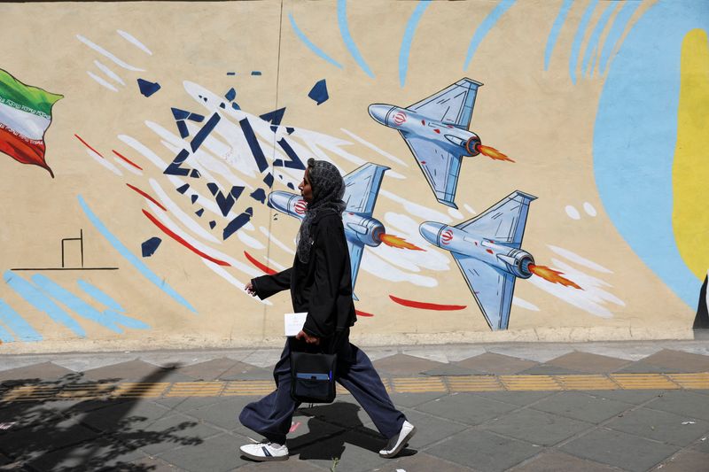 An Iranian woman walks past an anti-Israeli mural, after U.S. and Iranian officials said they had reached a deal to end their war and reopen the Strait of Hormuz, in Tehran, Iran, June 15, 2026. Majid Asgaripour/WANA (West Asia News Agency) via REUTERS