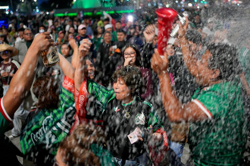 Fans celebrate near the Angel of Independence after Mexico won the 2026 FIFA World Cup match against South Korea, in Mexico City, Mexico, June 18, 2026. REUTERS/Armando Vega