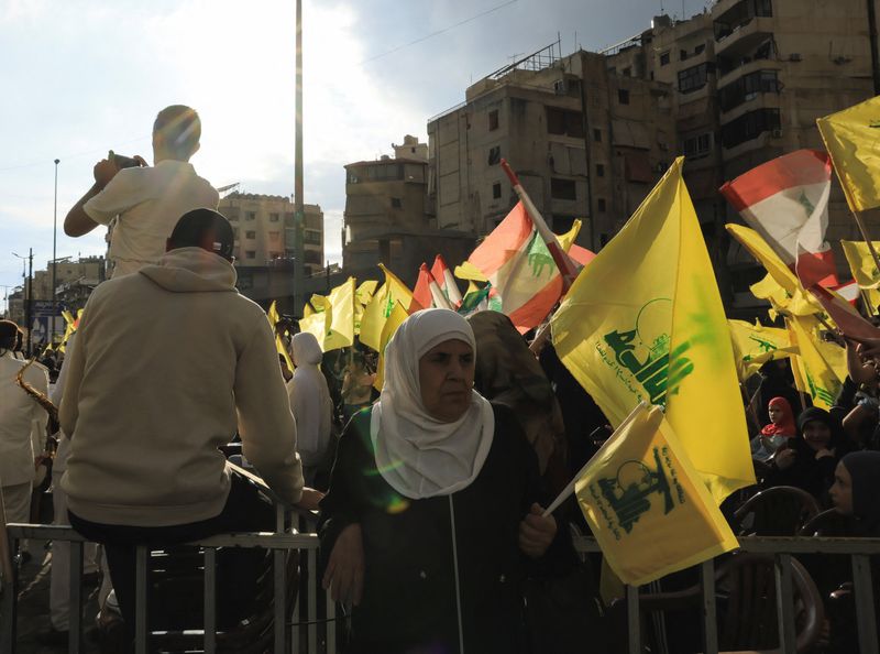 A woman holds a Hezbollah flag while commemorating Israel’s withdrawal from southern Lebanon in 2000, in Beirut's southern suburbs, Lebanon, May 25, 2026. REUTERS/Raghed Waked