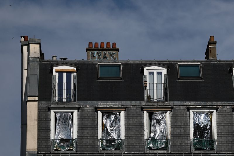 The windows of a Haussmann-style residential building are covered with emergency blankets to shield them from the sun, as temperatures rise in Paris, during a heatwave affecting a majority of the country, France, June 25, 2026. REUTERS/Gonzalo Fuentes
