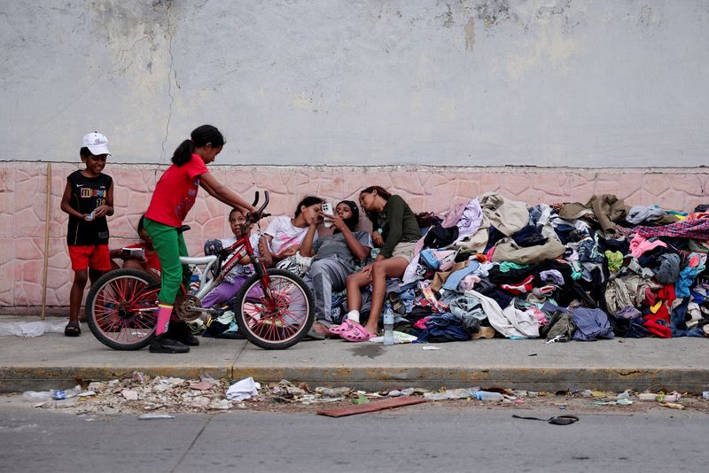 Children who lost their homes in the earthquakes, rest on a pile of donated clothes on a street, in La Guaira, Venezuela, June 29, 2026. REUTERS/Gaby Oraa     TPX IMAGES OF THE DAY