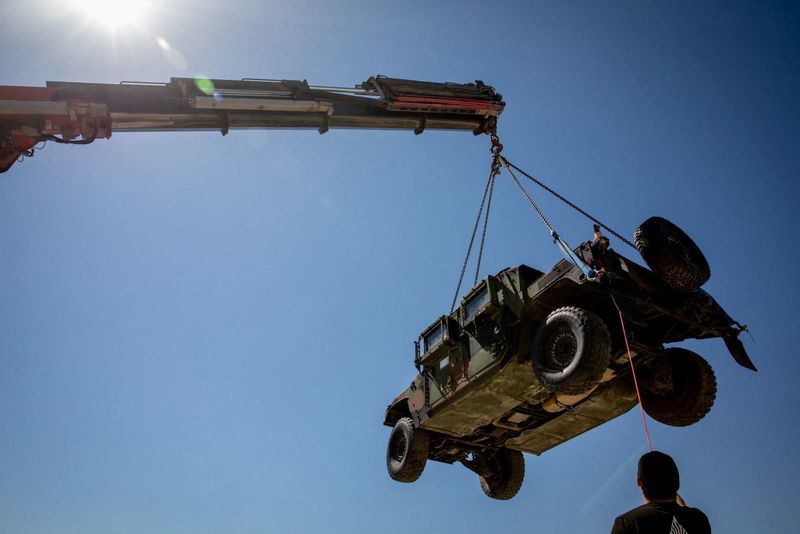 A crane hoists a tactical vehicle at the Logistics Support Area, in a location given as near Kerem Shalom, in this handout picture released June 30, 2026, by the Trump-appointed Board of Peace. Board of Peace/Handout via REUTERS  THIS IMAGE HAS BEEN SUPPLIED BY A THIRD PARTY. MANDATORY CREDIT. NO RESALES. NO ARCHIVES. VERIFICATION: Reuters could not independently verify the location and date of the pictures. However, the Board of Peace said that the Logistics Support Area is located near the Kerem Shalom crossing. No older versions of the photos were found posted online before June 30.