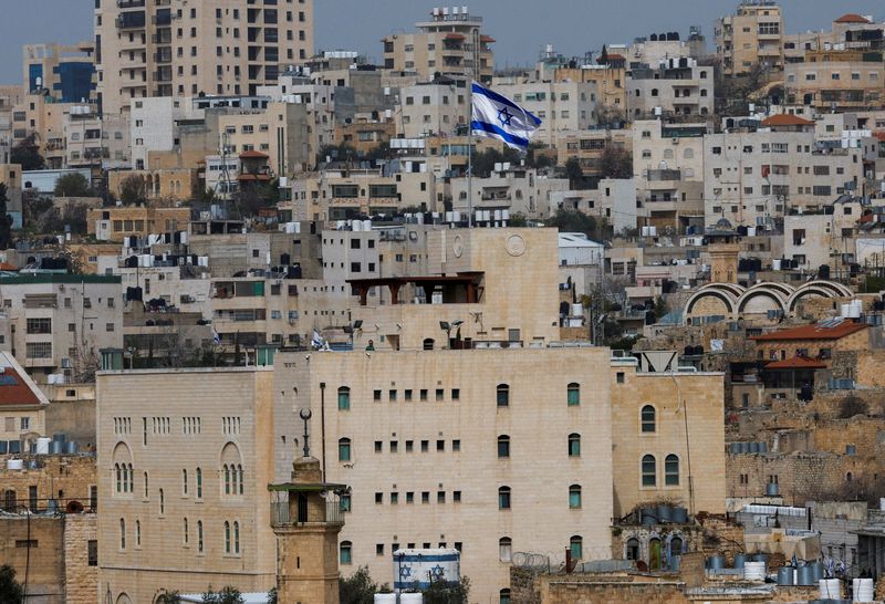 FILE PHOTO: An Israeli flag flies over an Israeli settlement in the old city in Hebron in the Israeli-occupied West Bank, February 9, 2026. REUTERS/Mussa Qawasma/File Photo