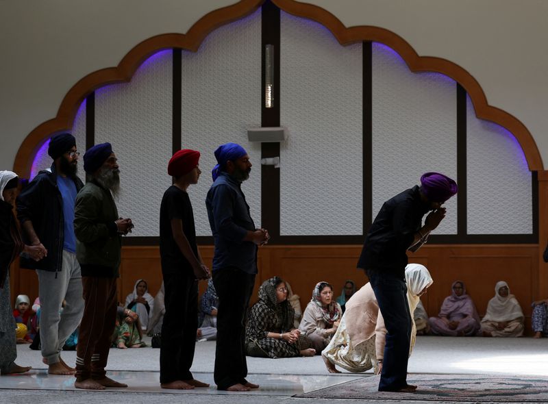 Men line up to give prayers on the first anniversary of the 2023 murder of Sikh separatist leader Hardeep Singh Nijjar, at the temple site where he was killed at Guru Nanak Sikh Gurdwara in Surrey, British Columbia, Canada June 18, 2024. REUTERS/Chris Helgren/File Photo