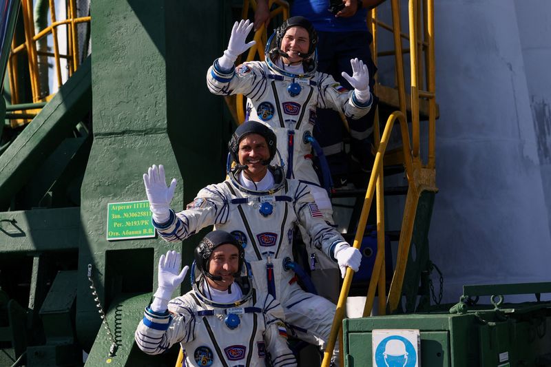 The International Space Station (ISS) crew members, NASA astronaut Anil Menon and Roscosmos cosmonauts Pyotr Dubrov and Anna Kikina, wave as they board the Soyuz MS-29 spacecraft for launch at the Baikonur cosmodrome in Kazakhstan, July 14, 2026.  REUTERS/Pavel Mikheyev/Pool